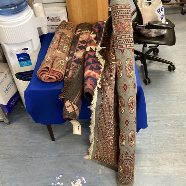 Lot of four vintage assorted rugs with patterned designs.