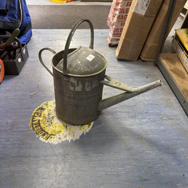 Vintage galvanised watering can with a weathered patina.