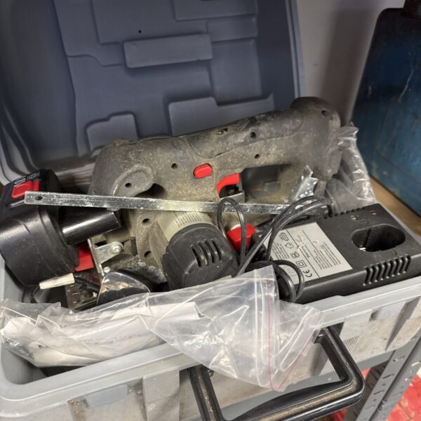 Cordless circular saw with battery and charger, presented for auction.