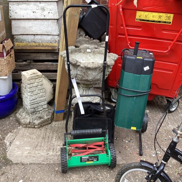 Vintage Powerbase push mower in a garden setting.