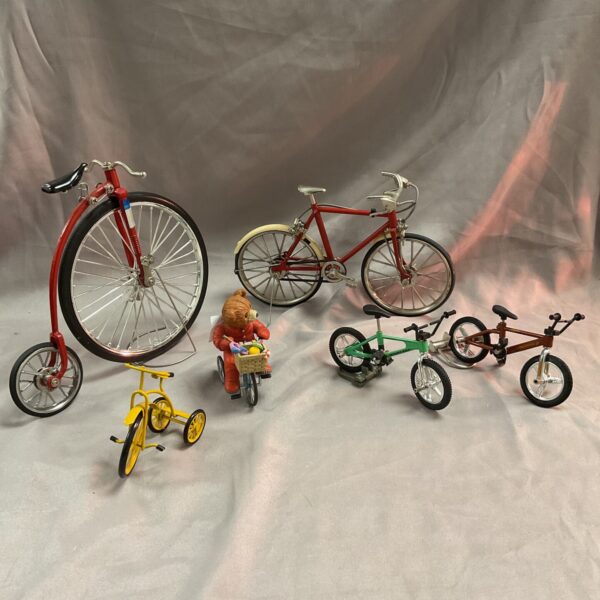 Vintage metal model bicycles, including a penny-farthing and road bike.