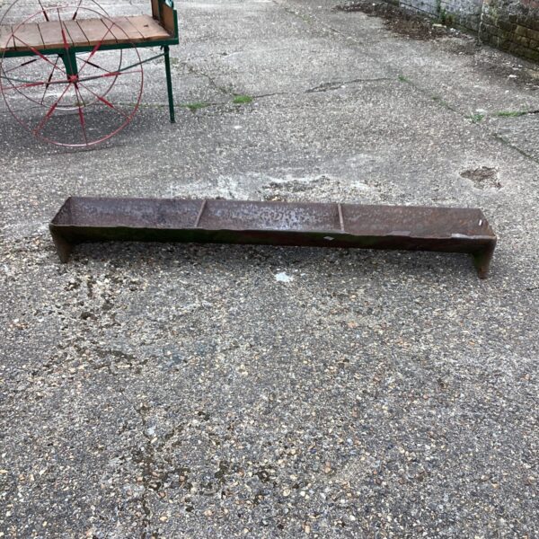 Weathered vintage iron trough, ideal for rustic garden displays.