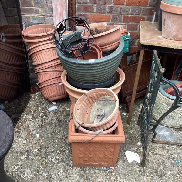 Mixed lot of terracotta and plastic garden pots and planters.