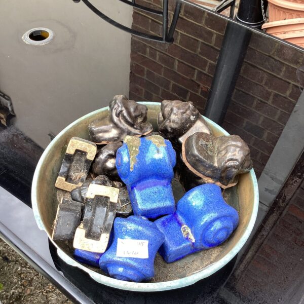 Lot of terracotta plant pot rests for garden use.