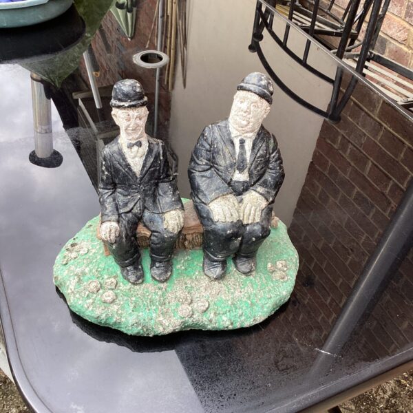 Vintage Laurel and Hardy garden ornament in a garden setting.