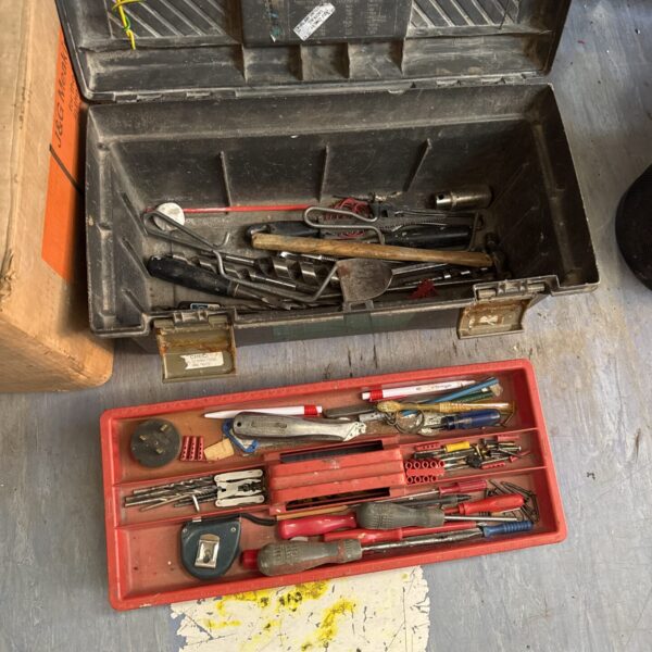 Vintage curved plastic toolbox filled with assorted hand tools.