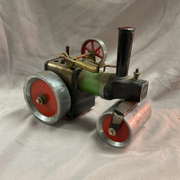 Vintage Mamod steam engine with red flywheel and metal construction.