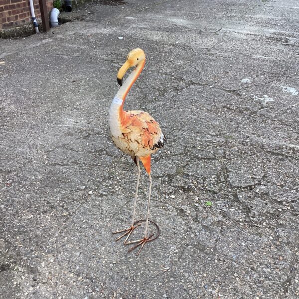 Vintage metal flamingo garden ornament with weathered patina.