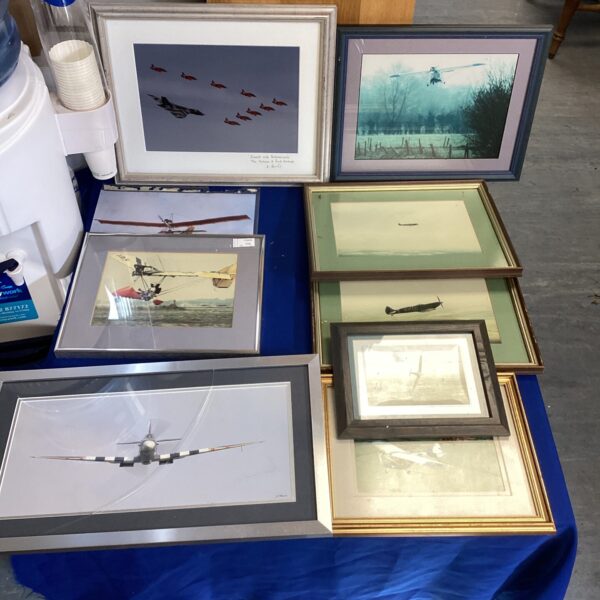 A collection of framed aviation pictures featuring vintage aeroplanes.