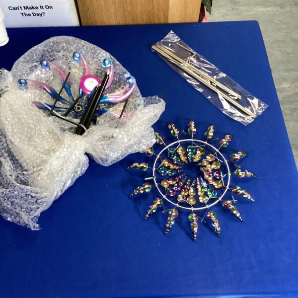 Colourful garden wind chime with acrylic droplets hanging from a circular frame.