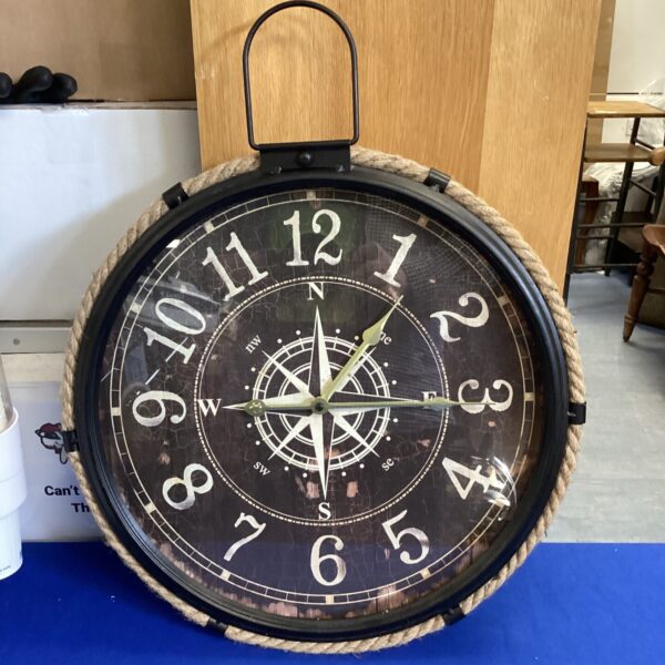 Vintage nautical clock with Roman numerals and compass detail.