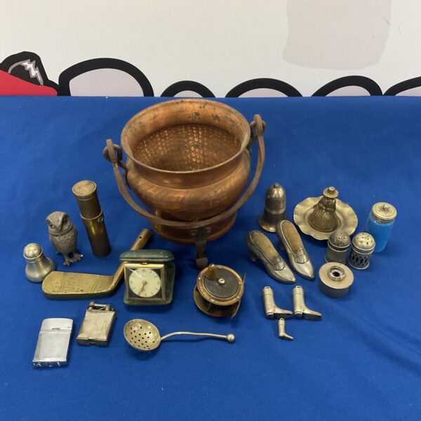 Vintage copper cauldron with antique curios and a fishing reel.