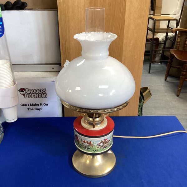 Vintage hunt scene table lamp with porcelain base and glass shade.