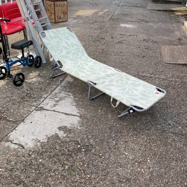 Folded garden sun lounger in an outdoor setting.