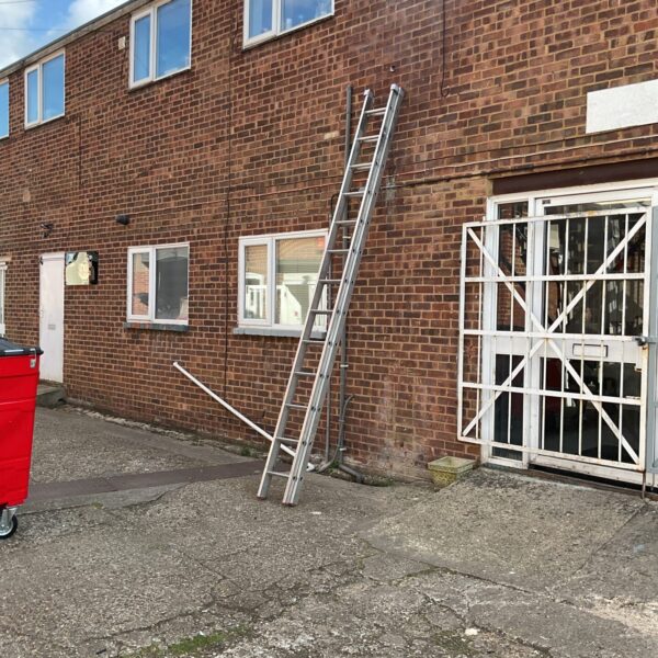 Aluminium Titan 7.1m extendable ladder leaning against a brick wall.