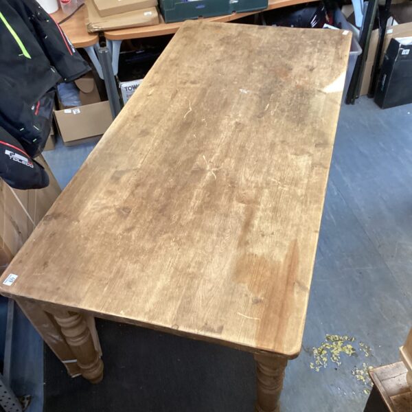 Large farmhouse pine table with turned legs, rustic country style.
