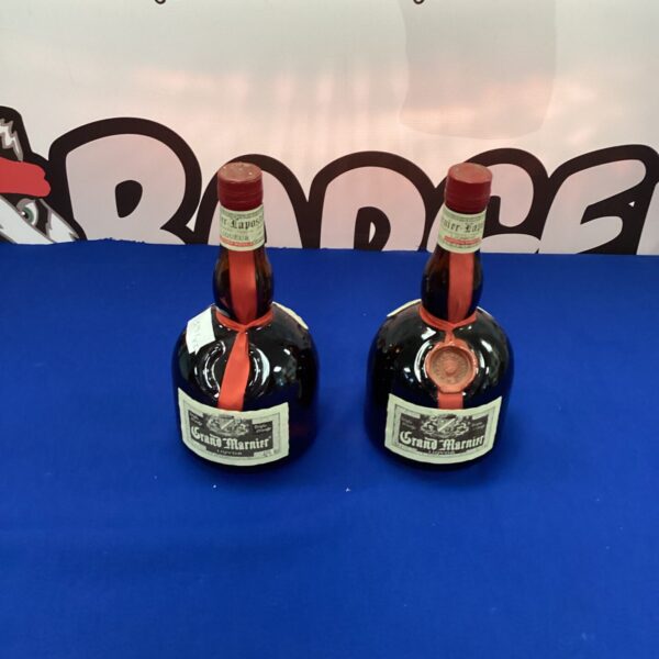 Two bottles of vintage Grand Marnier orange liqueur.