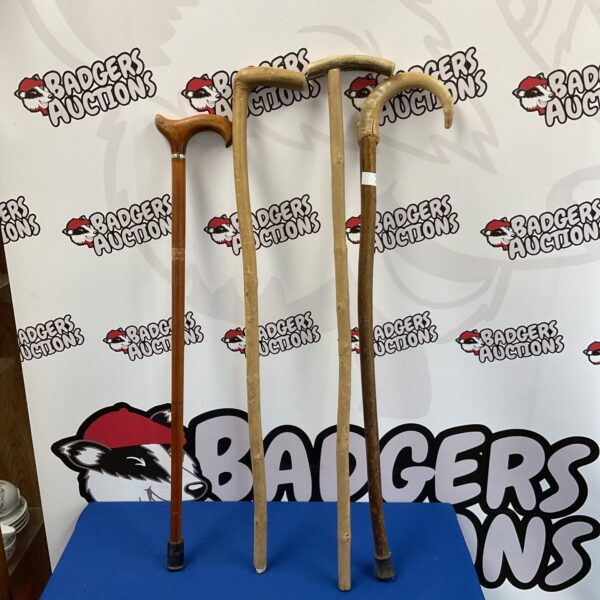 Lot of four vintage wooden walking sticks with ornate handles.