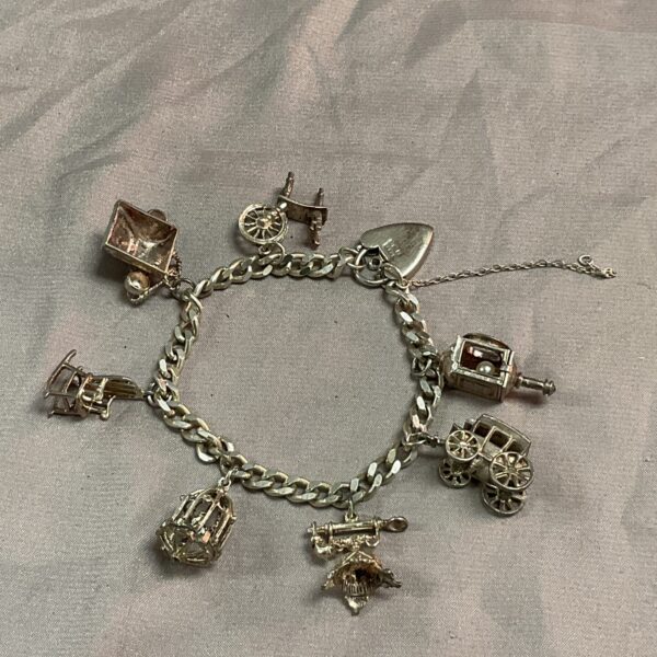 Vintage silver charm bracelet featuring a steam engine charm.