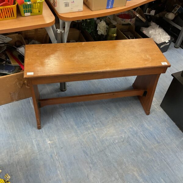 Front view of a vintage wooden music bench with storage.