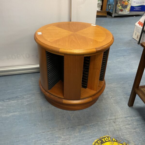 Vintage oak CD rack with spinning base for media storage.