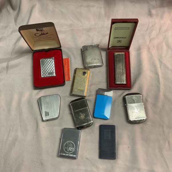 Vintage cigarette lighters including Zippo and Colibri brands in a collection.