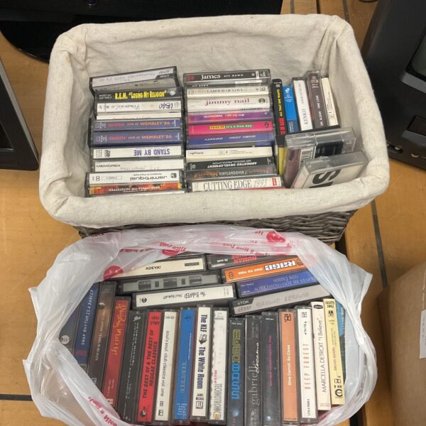 Vintage cassette tape collection featuring REM and Queen music.