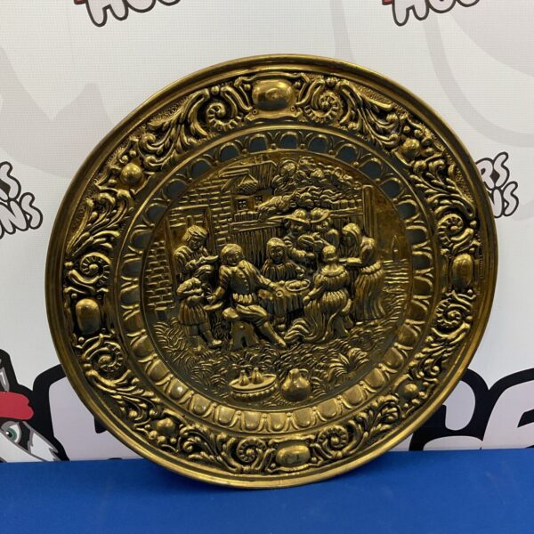 Vintage brass tavern charger with detailed tavern scene.