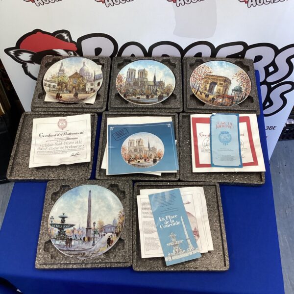 Set of vintage French landmark collector plates for display.