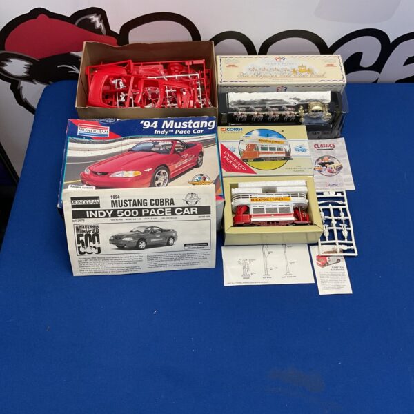 Model kit lot featuring Revell Mustang, Corgi tram, and Her Majesty’s Coach.