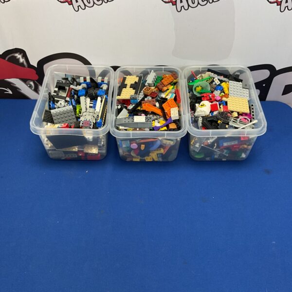 Three boxes filled with a colourful assortment of mixed Lego building blocks.