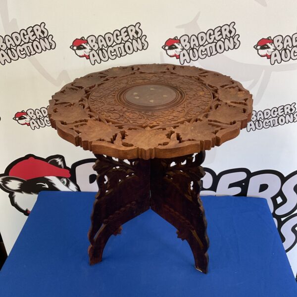 Intricately carved Indian wooden folding table with floral designs.