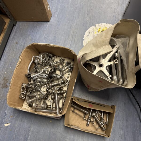 Vintage bicycle parts lot with gears and derailleurs.