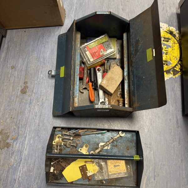 Vintage metal toolbox filled with antique hand tools for workshop storage.