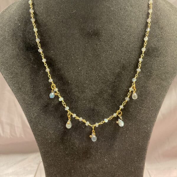 Delicate silver gilt teardrop necklace on a neutral background.