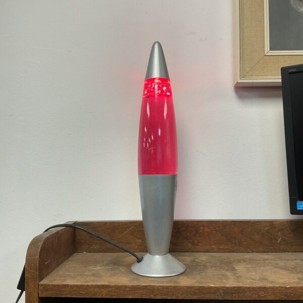 Vintage pink glitter lava lamp on a wooden surface.