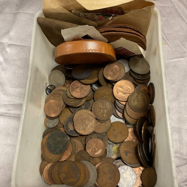 Assorted vintage coins and postage stamps in a tub.