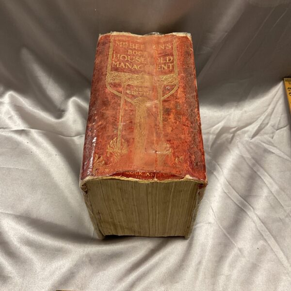 Antique Mrs Beeton's Household Management book with worn cover.
