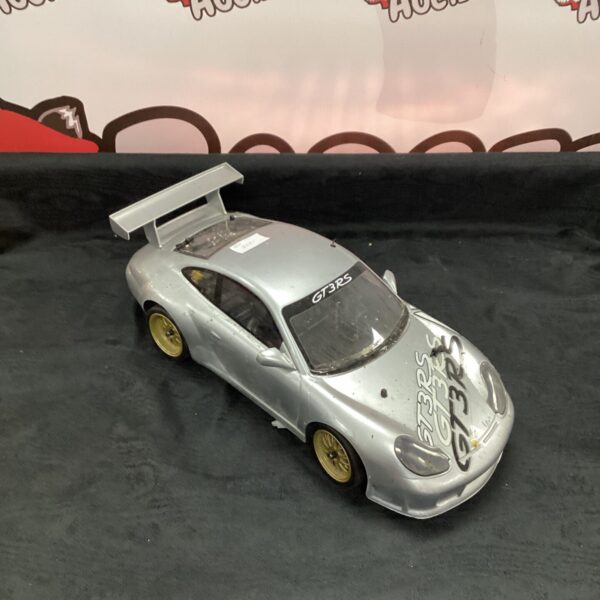 Silver Porsche GT3 RS RC car with yellow wheels.