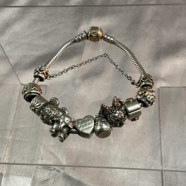 Silver Pandora charm bracelet with Disney charms and gold clasp.