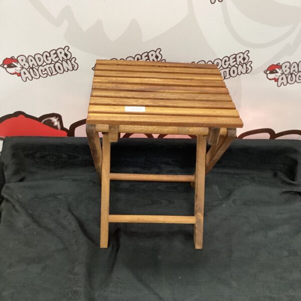 Small wooden folding garden table, side view.