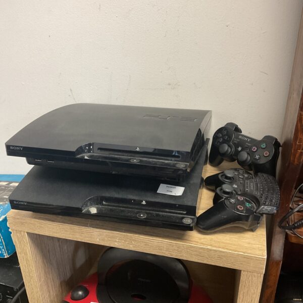 Two Sony PlayStation 3 Slim consoles with controllers for gaming.
