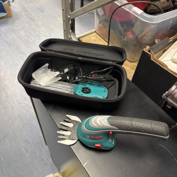 Bosch cordless trimmer kit with charger and attachments in carrying case.