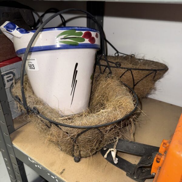 Vintage wrought iron plant baskets with a decorative ceramic pot.