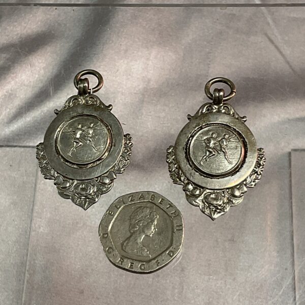 Two hallmarked silver running medals with running figure design.