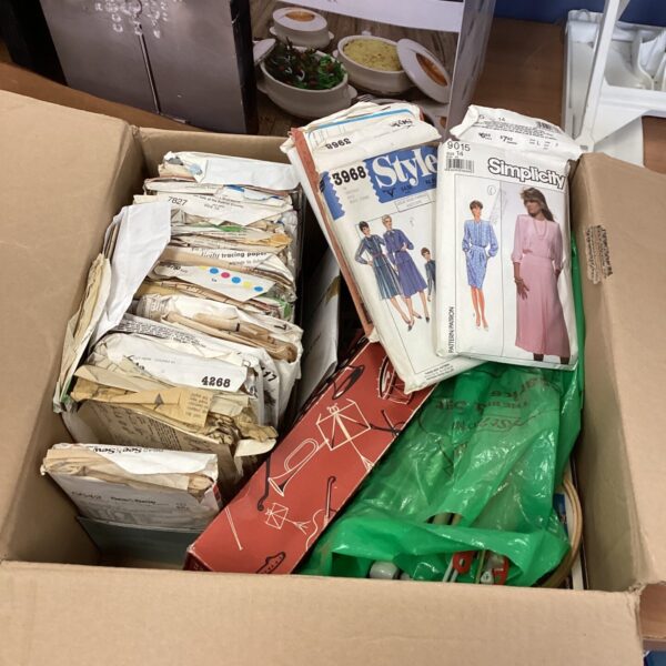 Box of sewing and knitting items with dress making patterns