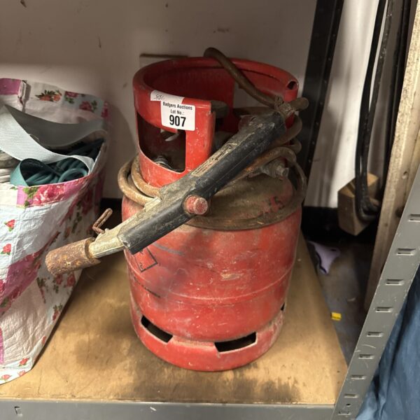 Vintage red gas blow torch with metal bottle.