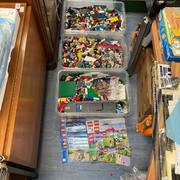 Large crates filled with mixed Lego bricks and figures.