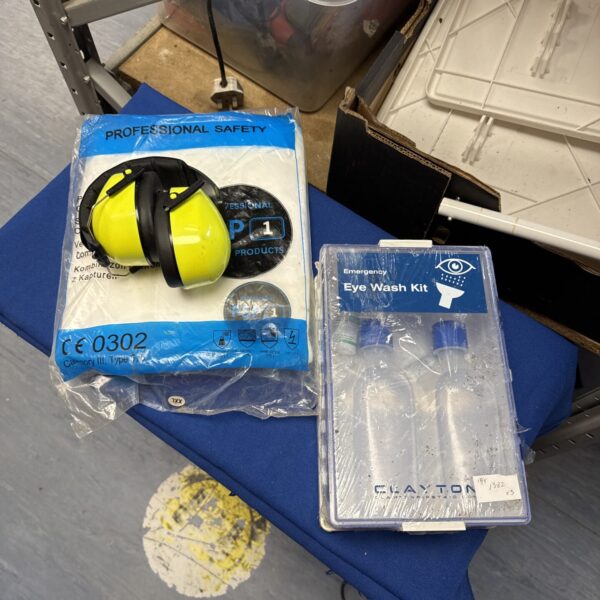 Overview of the safety equipment set including overalls, earguards and eye wash station.