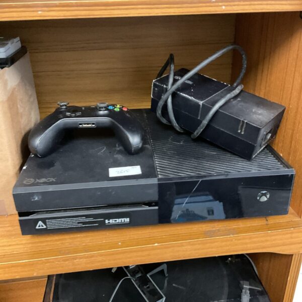 Microsoft Xbox One console with controller and power supply.